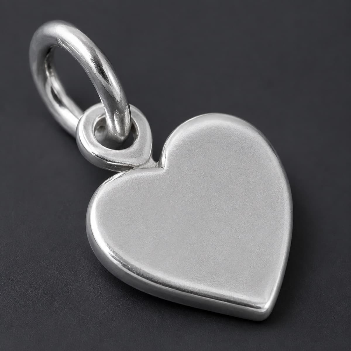 Heart Charm Plain 10 mm in solid 925 sterling silver, photographed against a dark grey background
