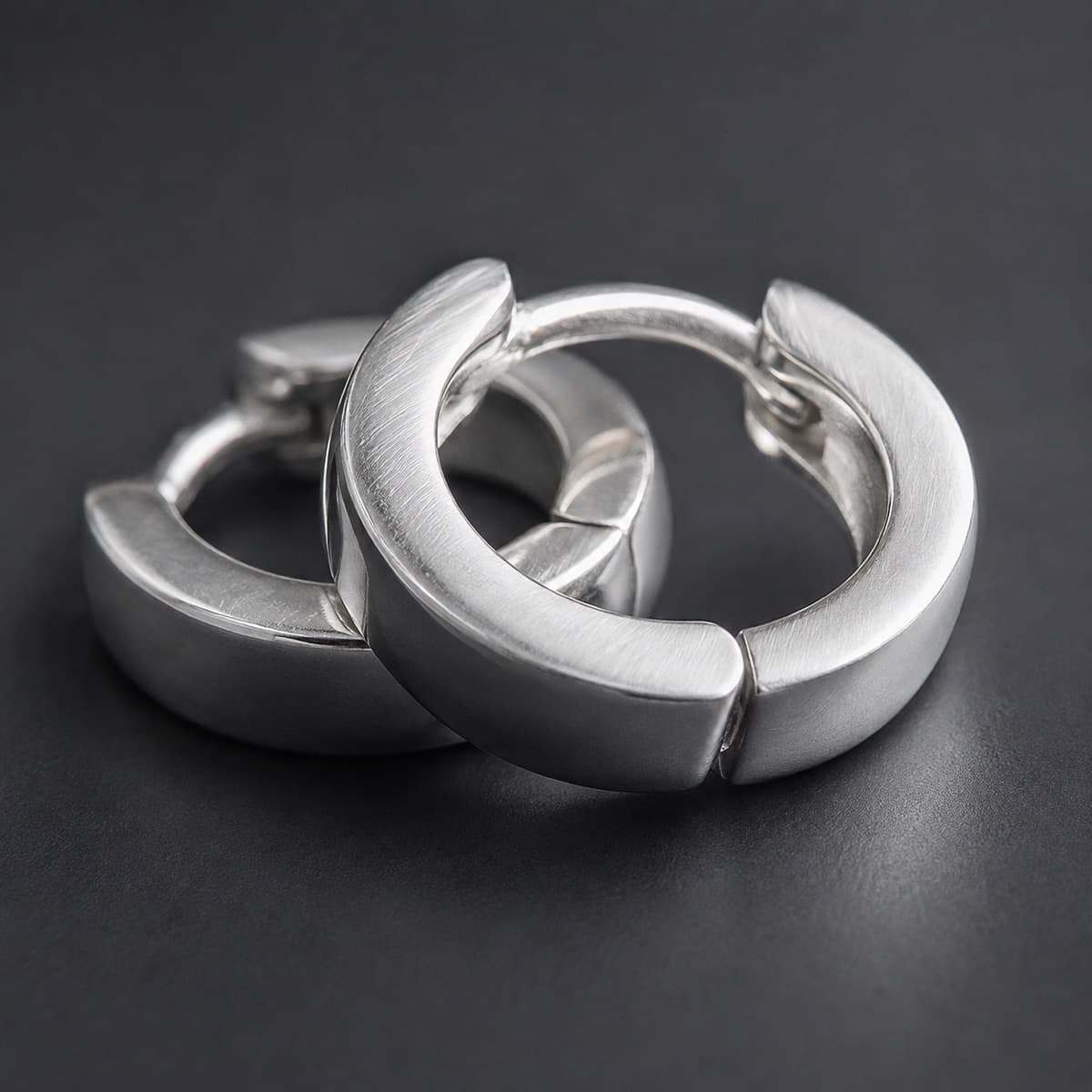 Huggie Hoop 10 mm Pair in solid 925 sterling silver, photographed against a dark grey background