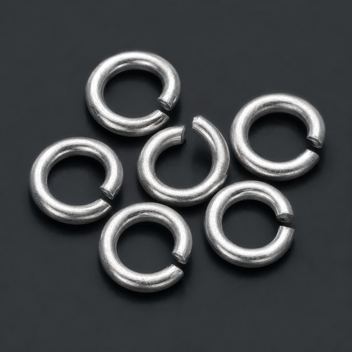 Jump Ring Set of 6 in solid 925 sterling silver, photographed against a dark grey background